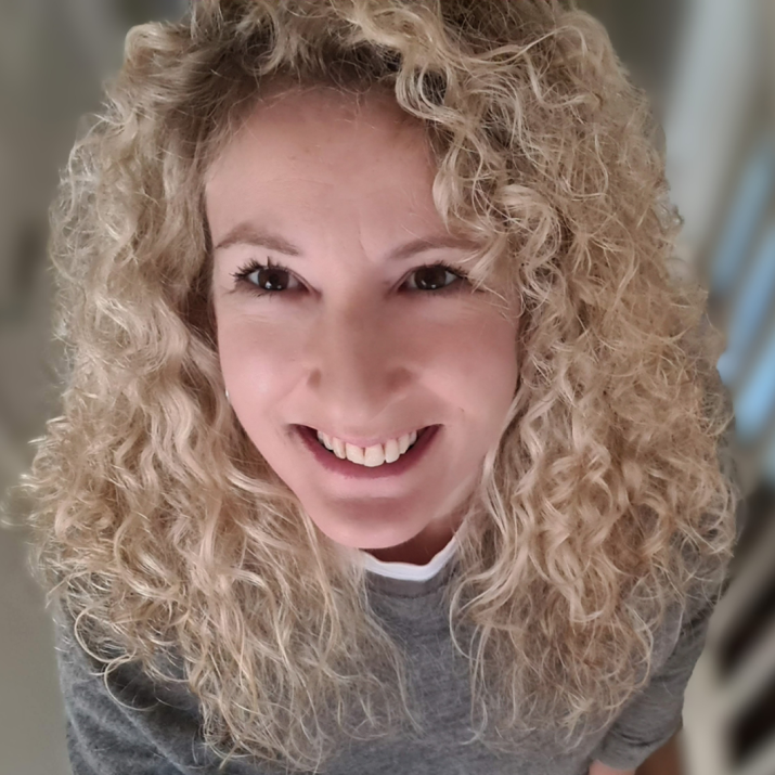 Sophie Cloutterbuck smiling towards the camera. Sophie wears a grey sweater.