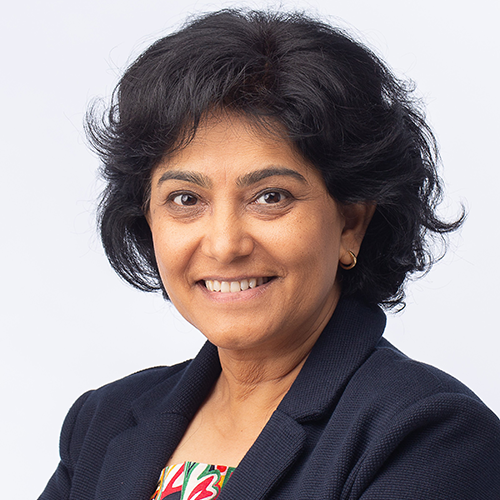 Headshot of Trusha Lakhani. She is smiling and wears a blouse and black blazer.