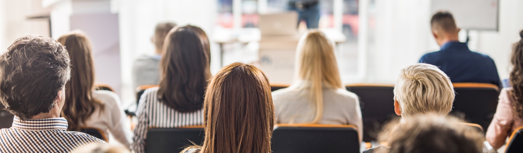 Rear view of business people attending a seminar in board room