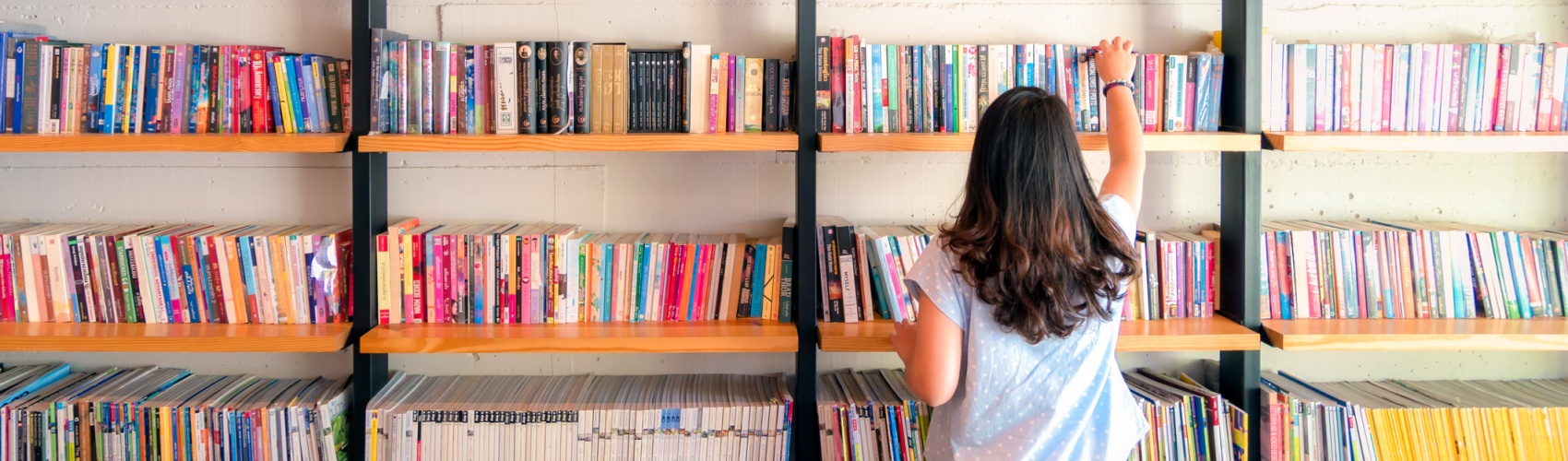 Asian women are picking up books on the bookshelf. To prepare to back to school