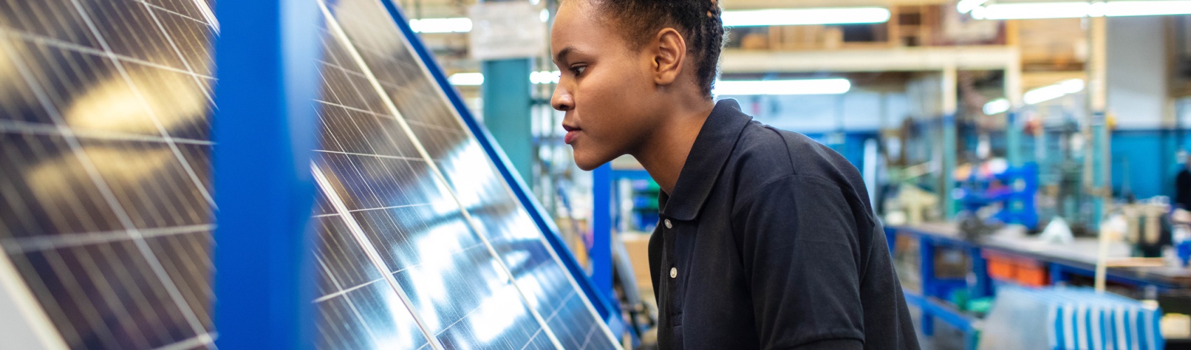 Quality engineer examining solar panels in factory