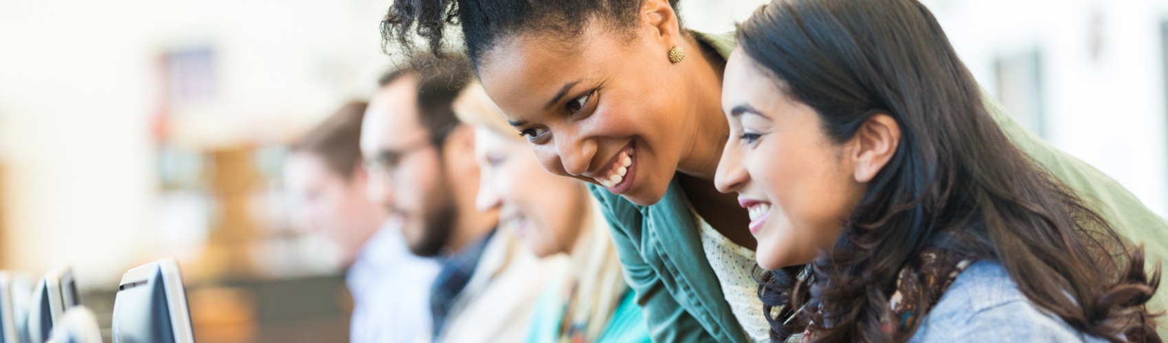 Diverse mid adult students using computers during class in college