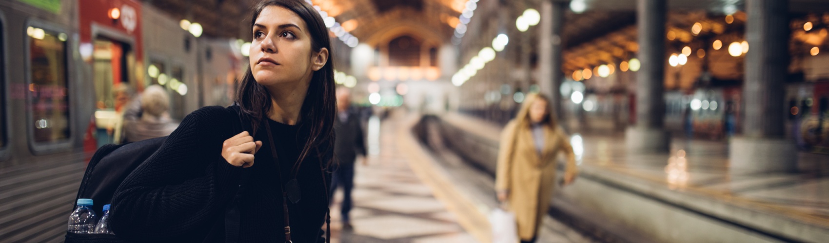 Female traveler searching for directions,waiting for the train/tram,using transportation in foreign country.Urban tourism.Low budget cheap ticket backpacking