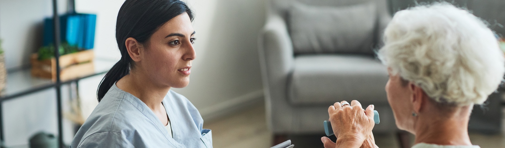 A nurse sitting on the sofa with a patient listening to her