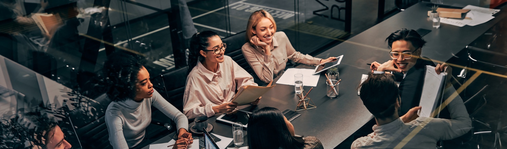 A group of researchers sit in a modern room in conversation