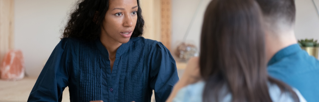 Female realtor consult young couple at office meeting