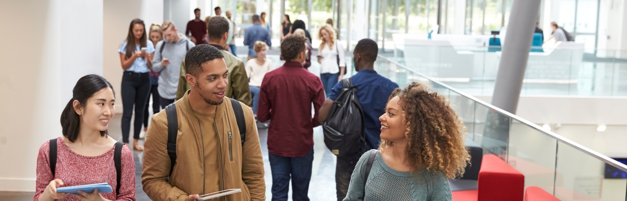 A group of students walking down a hallway in a university