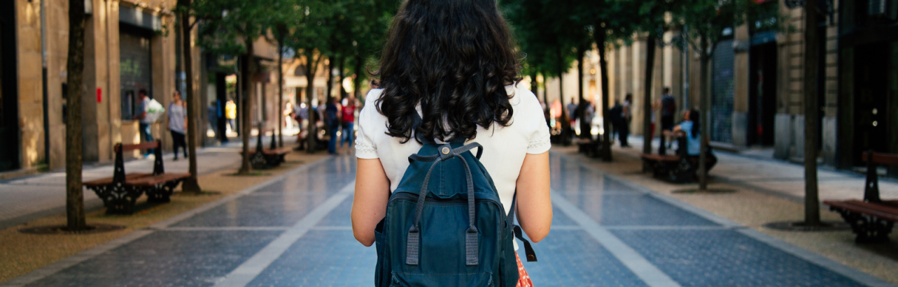 Girl with a backpack in a public square