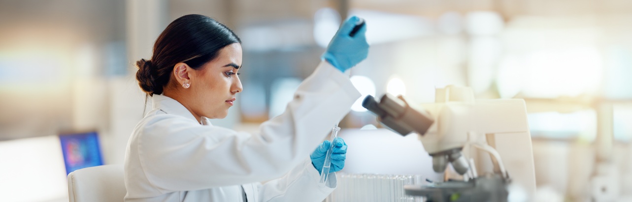 A scientist using test tubes in a lab