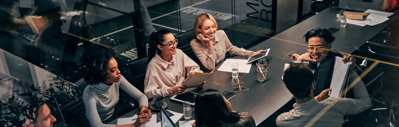 A group of researchers sit in a modern room in conversation