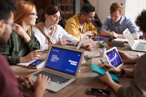 A group of students work around a table and chat